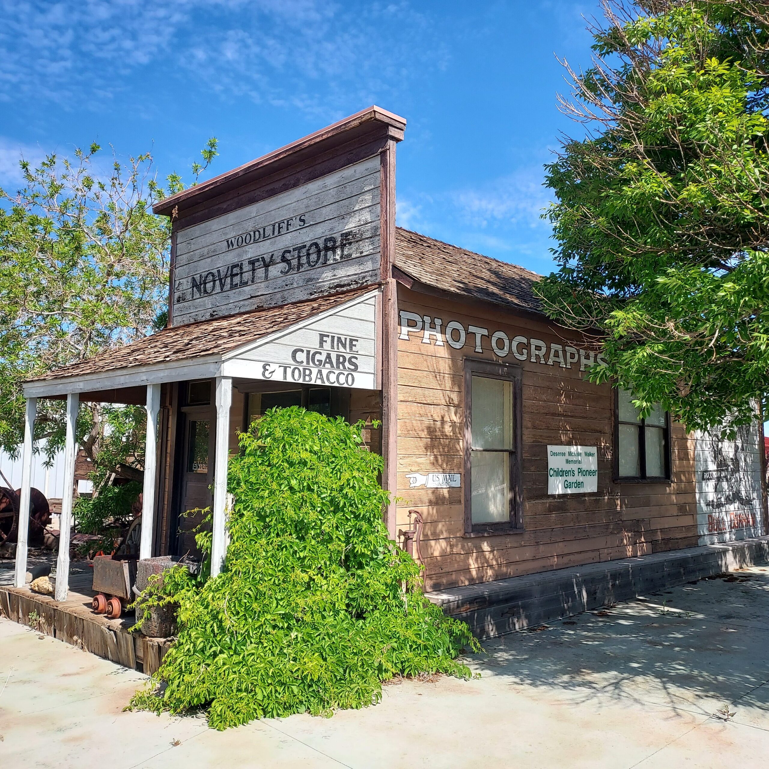 The woodliff building today at the Museum, a small wooden building with a large sign reading "novelty store"
