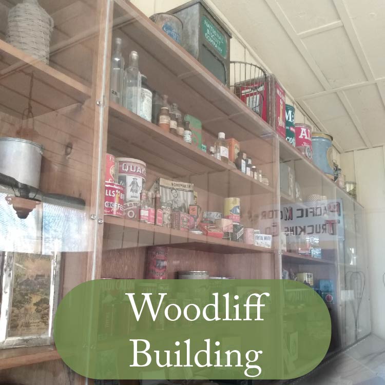 Image of shelves filled with turn of the century products, with button reading "woodliff building"